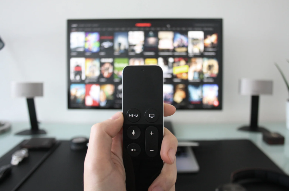 Viewer uses a remote to compare the best devices for multiple streaming services on a TV.