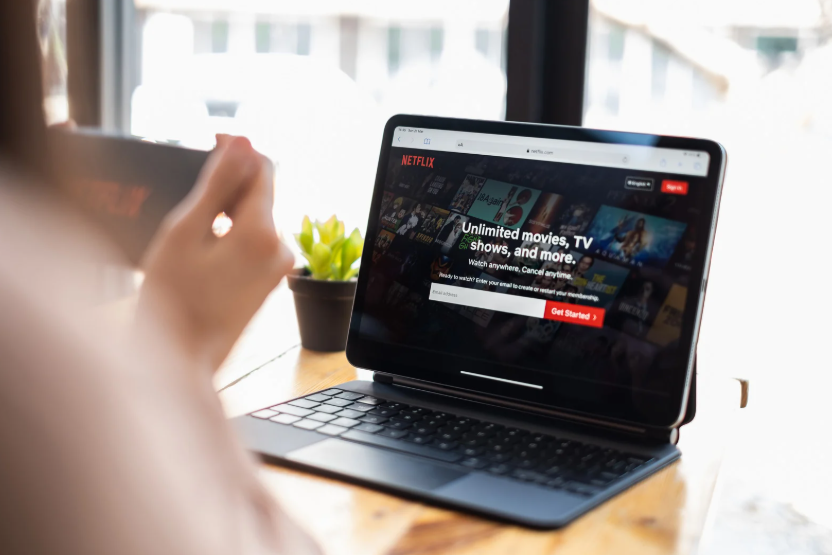 Viewer comparing Netflix Basic vs Premium plans on a laptop before choosing a subscription.