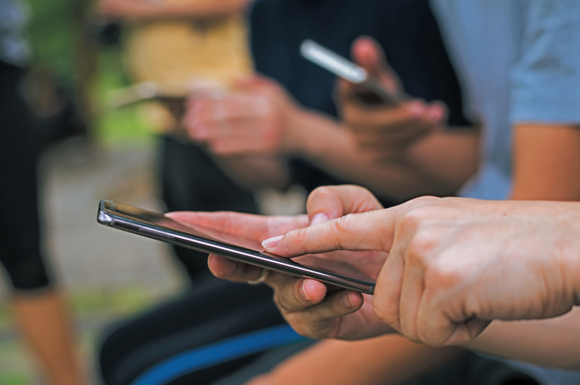 People comparing T-Mobile vs Verizon vs AT&T plans on smartphones for coverage, perks, and value.