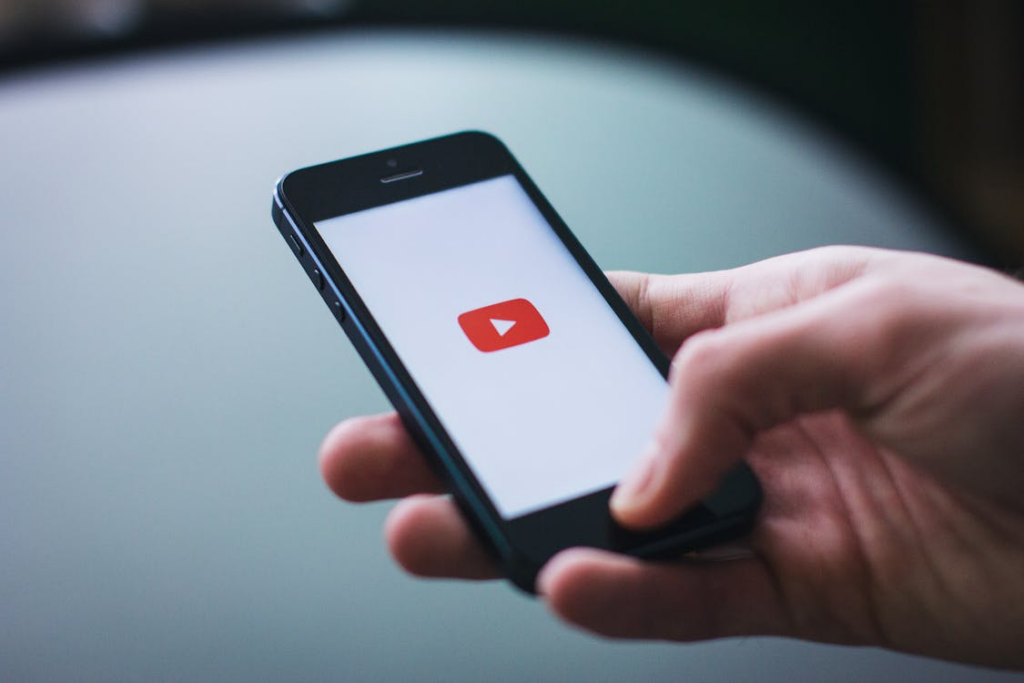 Viewer opening YouTube on a phone while comparing YouTube Premium vs Free features.